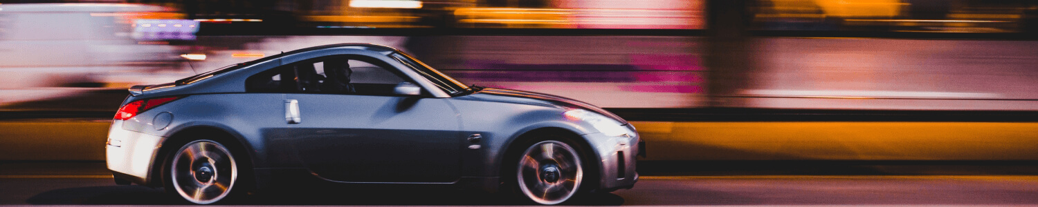 Car driving past neon lights